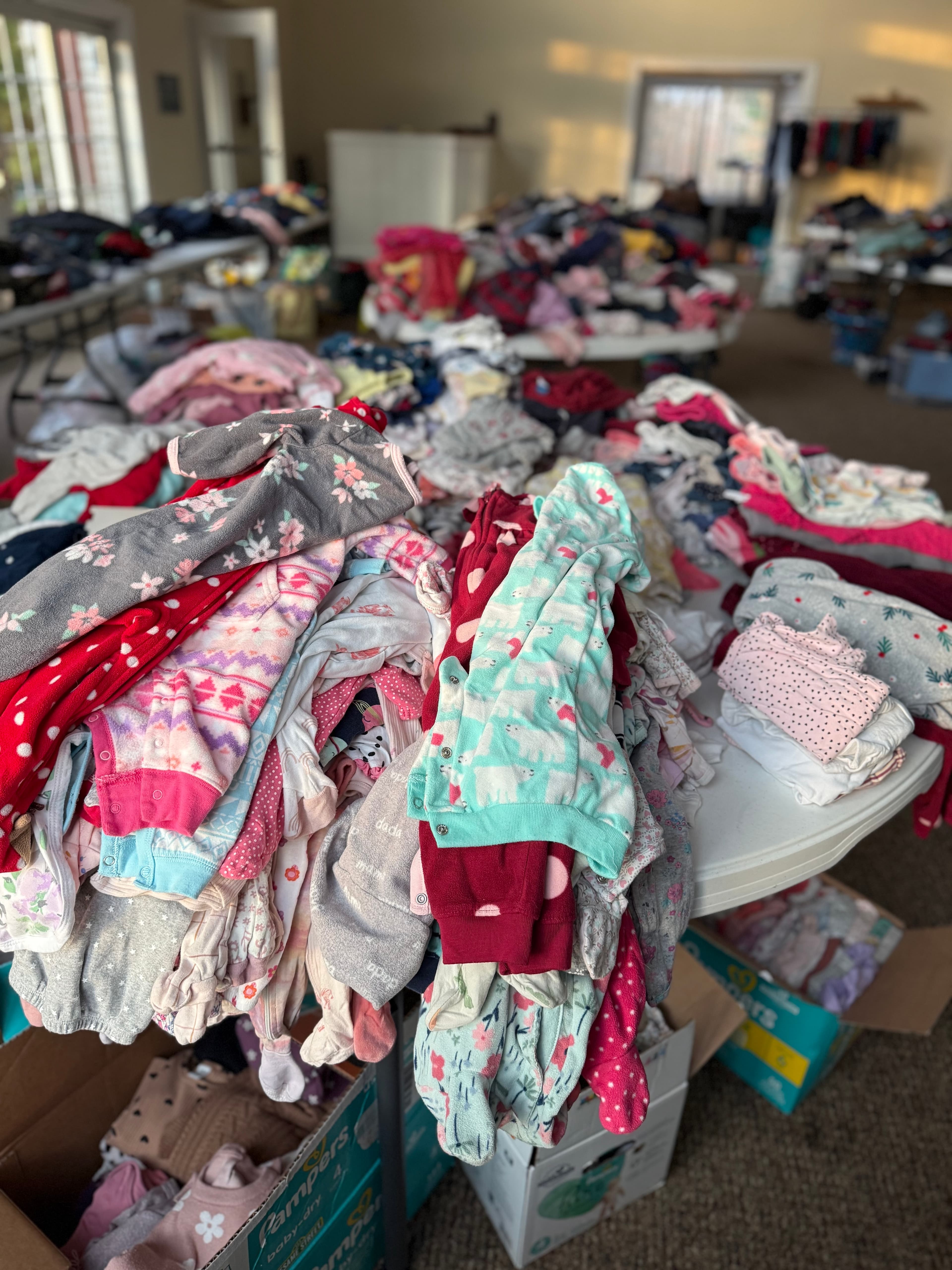 Seasonal children’s clothes and pajamas laid out on a table