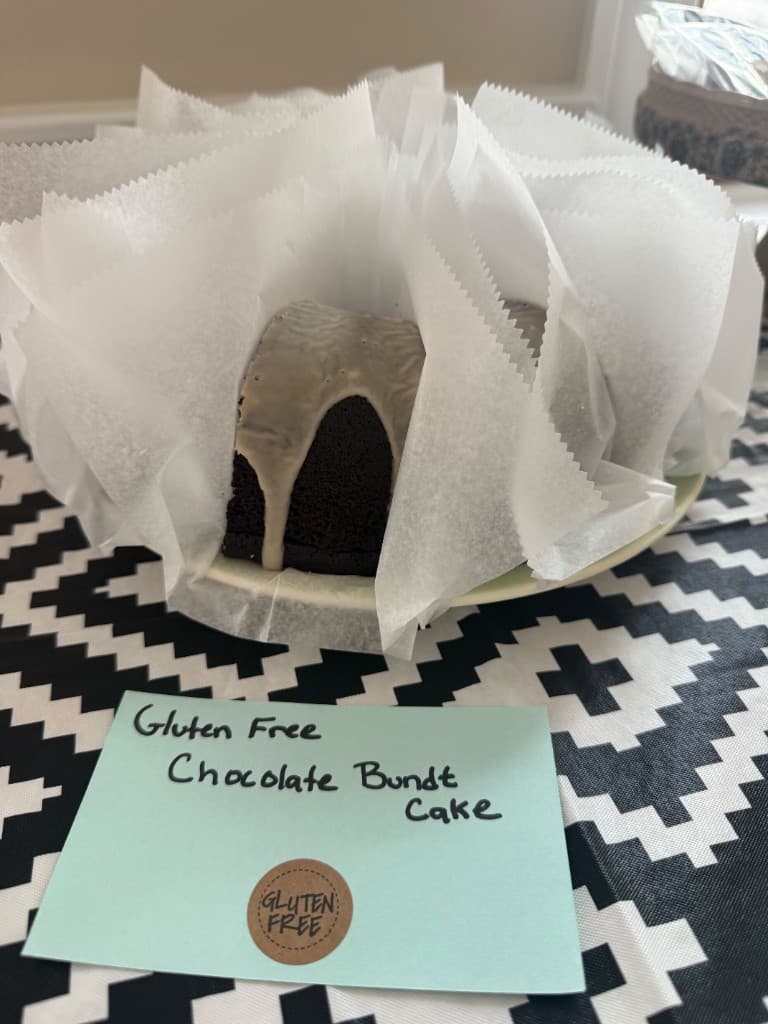 Gluten-free chocolate bundt cake with handwritten label at the refreshment table