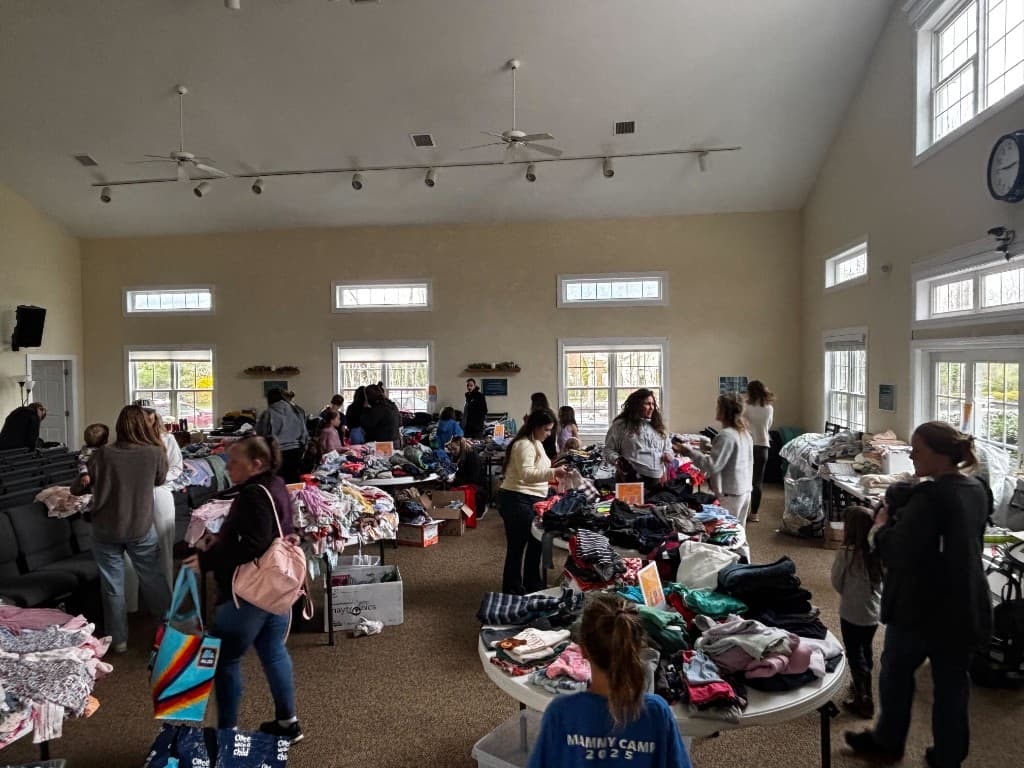Families browsing tables of children's clothing at the KBK Kids Community Closet spring event