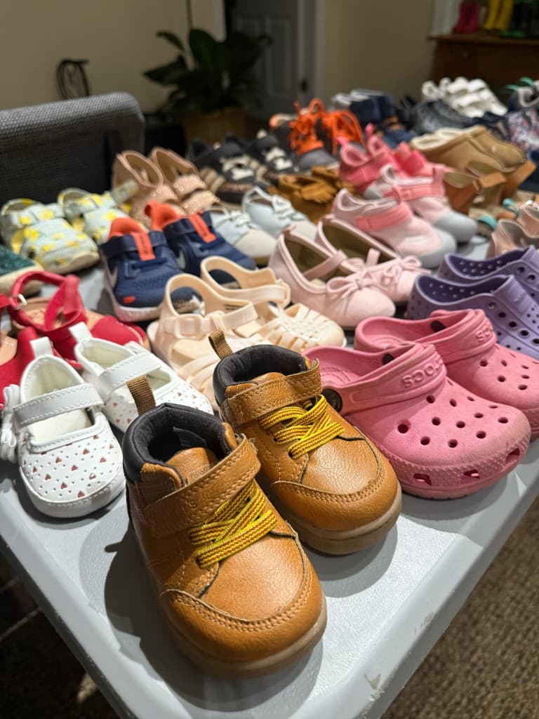 Rows of children's shoes arranged on a folding table